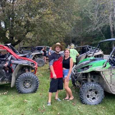a person standing next to a motorcycle in front of a green field