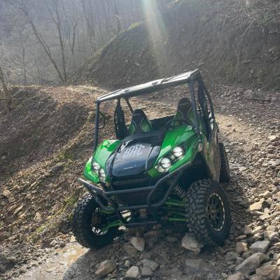 a green motorcycle parked on a dirt road