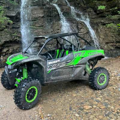 a green car on a dirt road